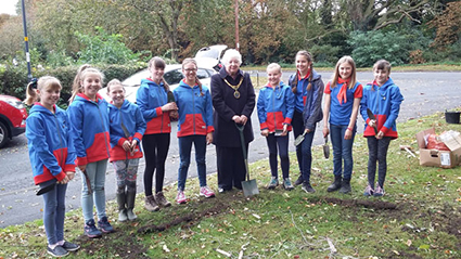 a group of girls and the mayor planting bulbs