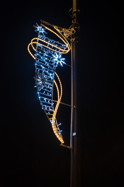 close up of a blue and yellow flag decoration on a street light